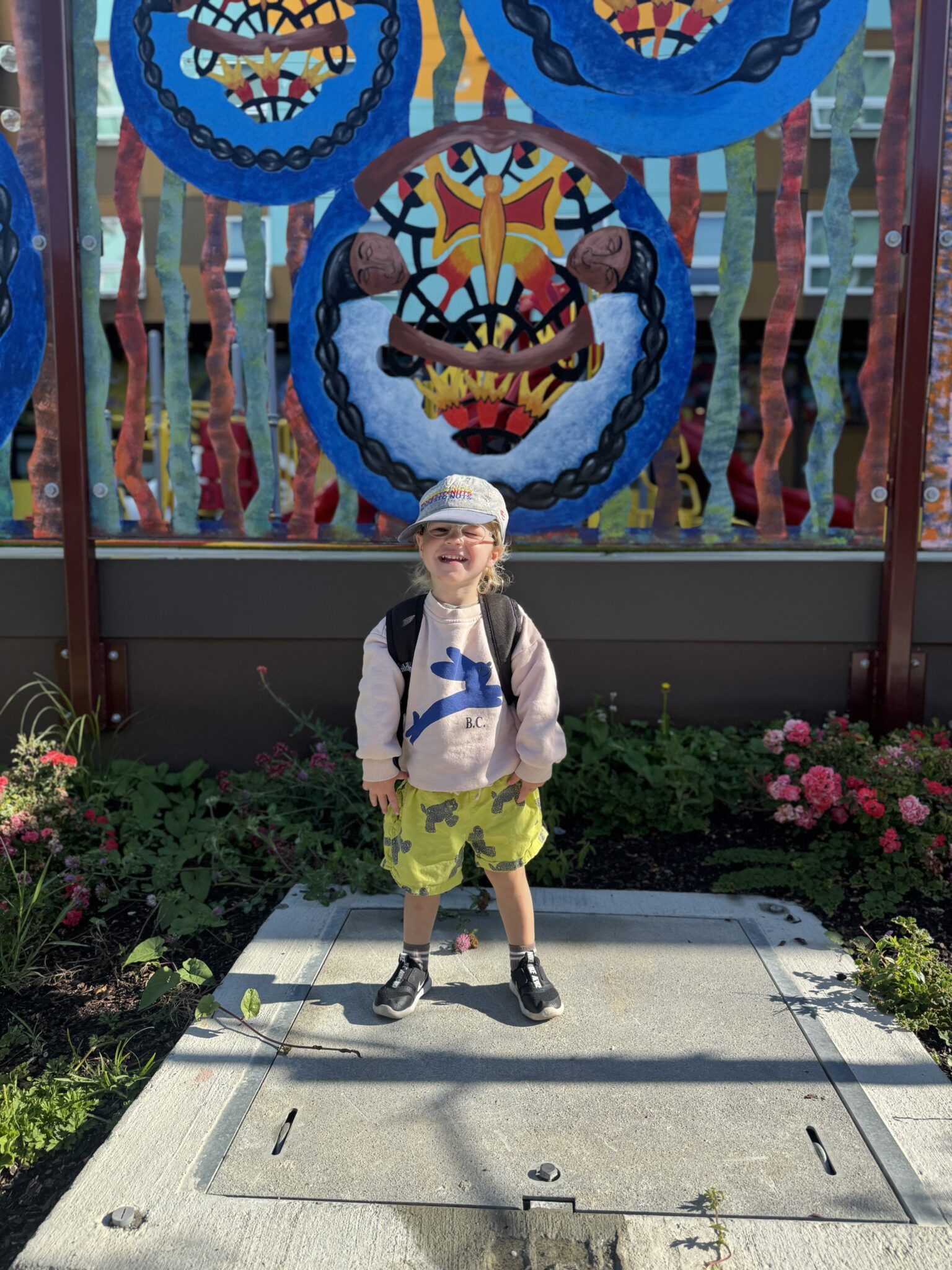 Child smiling outside preschool on the first day of school.