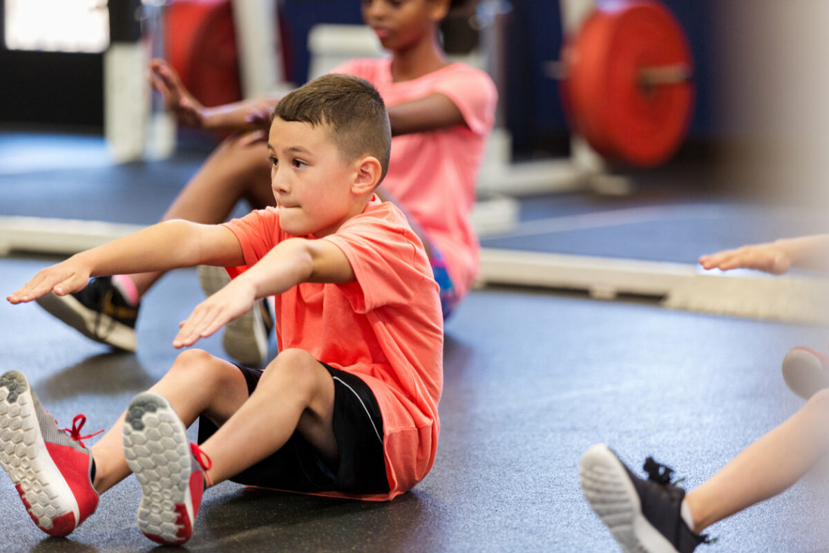 Students performing physical fitness test in school gymnasium