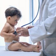 Baby receiving a checkup from a pediatrician during a routine health exam