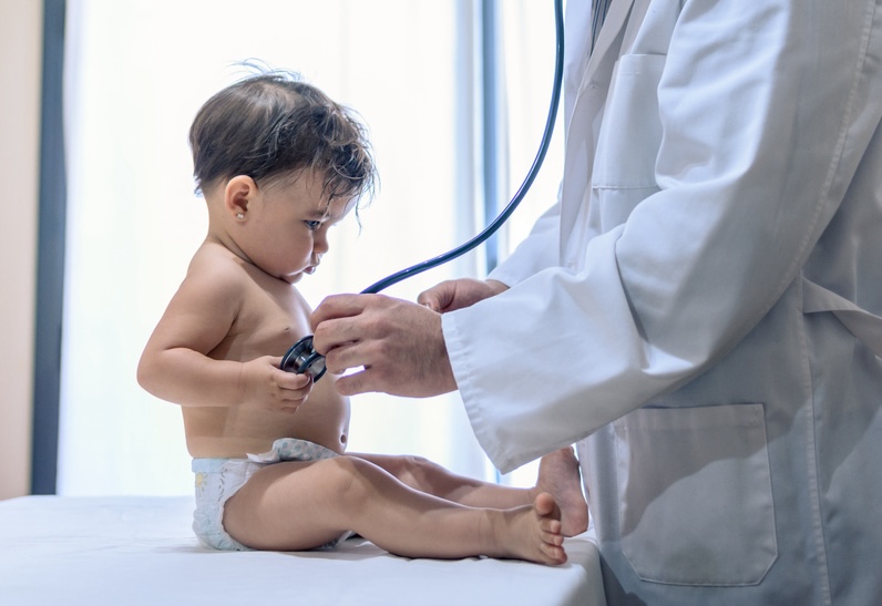 Baby receiving a checkup from a pediatrician during a routine health exam