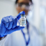 Doctor holding a vial of the updated COVID-19 vaccine booster.