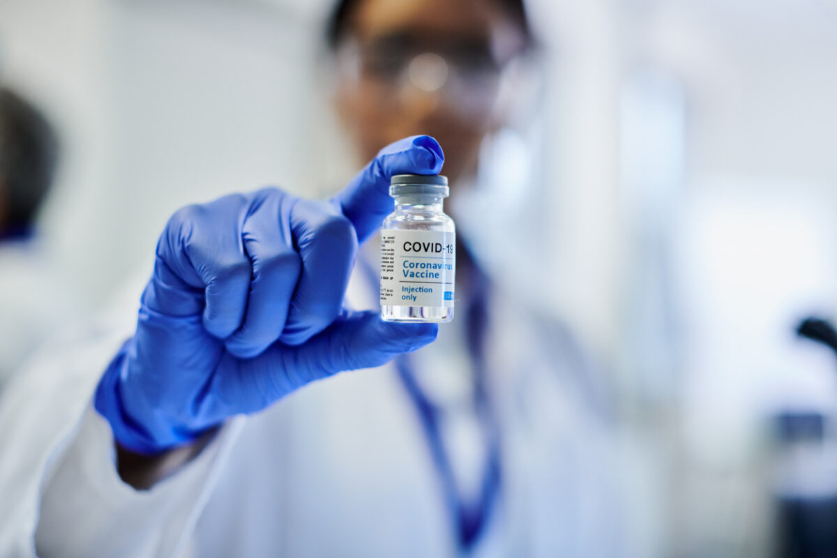 Doctor holding a vial of the updated COVID-19 vaccine booster.