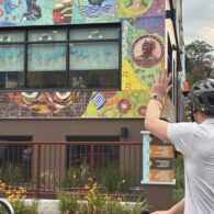 Dad waves goodbye to his preschooler through the classroom window during drop-off.
