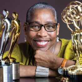 Val Thomas-Matson, producer and star of “Look, Listen and Learn,” smiling while holding Emmy and Telly Awards.