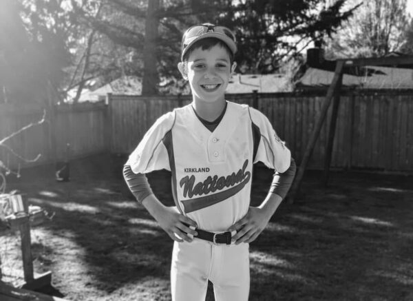 Young baseball player in uniform smiling before a game.