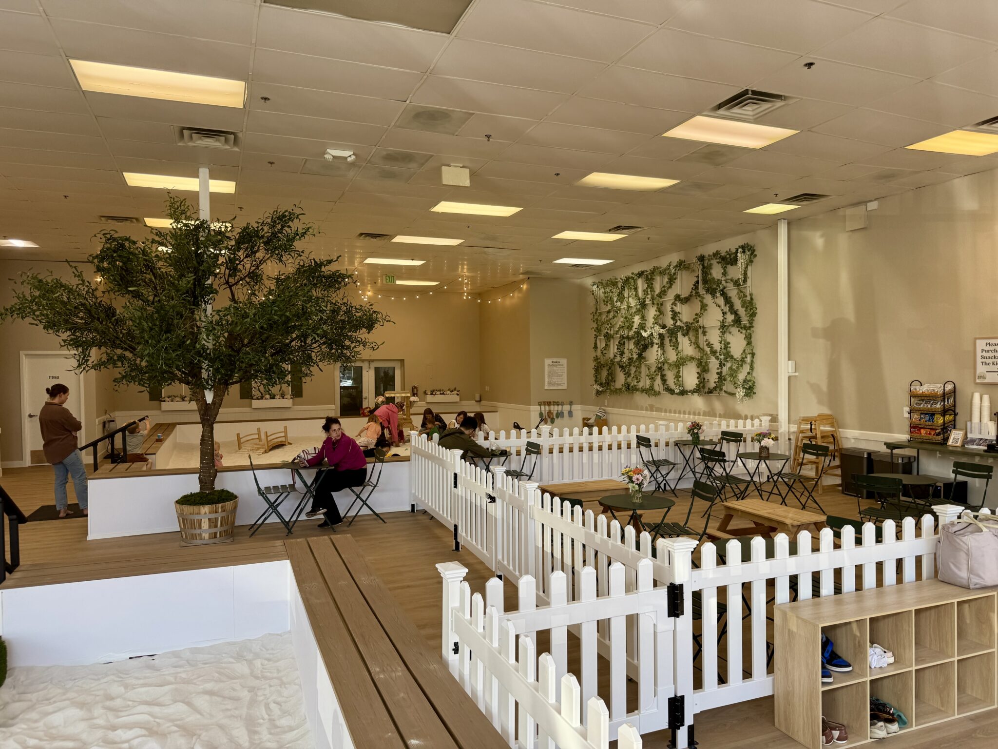 Parent seating area at Sand Garden with tables, chairs, and a clear view of the sandbox