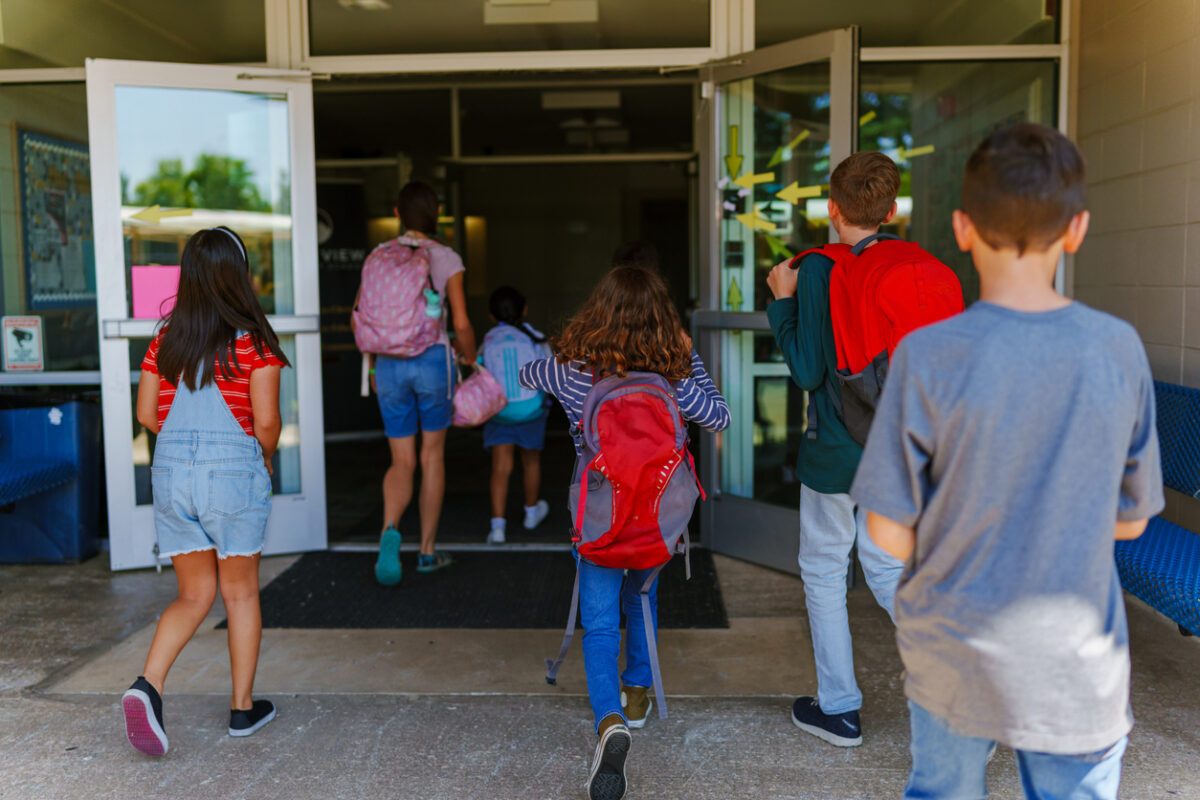Elementary age students arriving at school