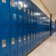 A row of closed lockers in a school hallway, symbolizing the education system